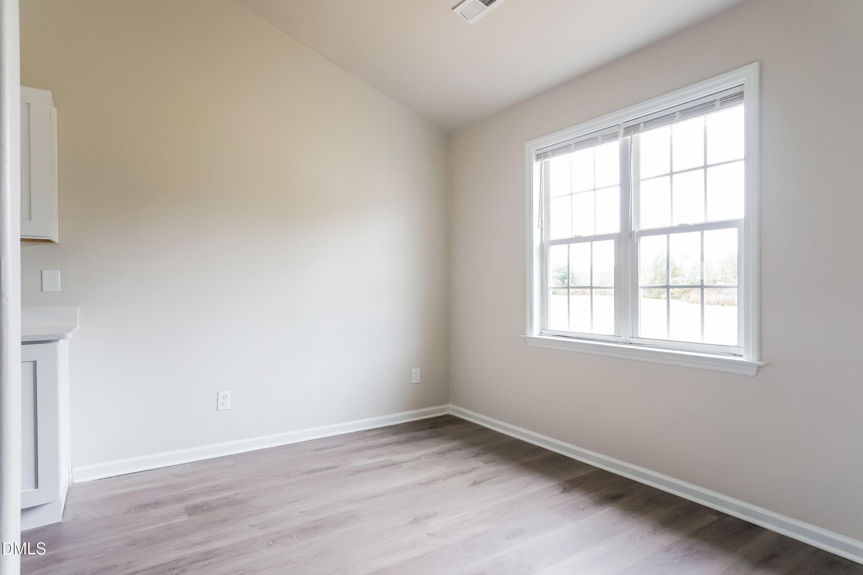 99 Jethro Circle Smithfield, NC 27577 - Photo 5 of 16 an empty room with wooden floor and windows