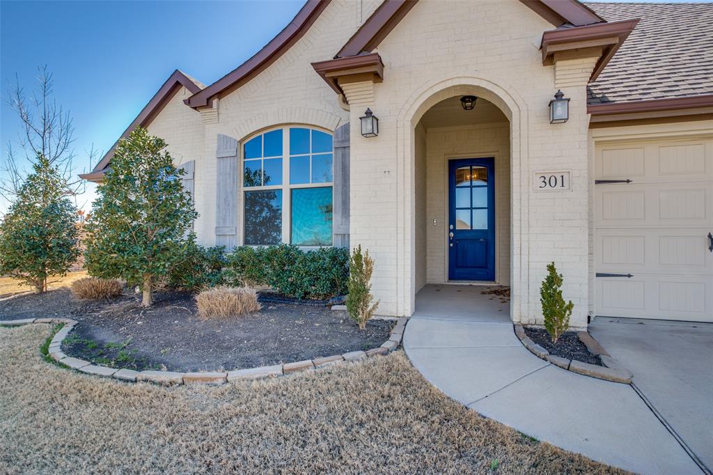a view of a white house with potted plants
