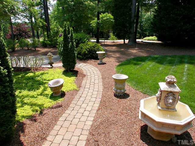 1528 Tradescant Court Raleigh, NC 27613 - Photo 4 of 25 Gorgeous landscaping and brick walkway with fountain. Exterior Back