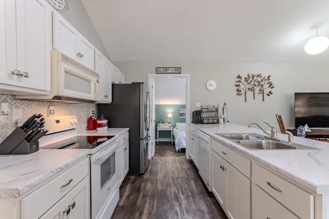 a kitchen with a refrigerator sink and cabinets
