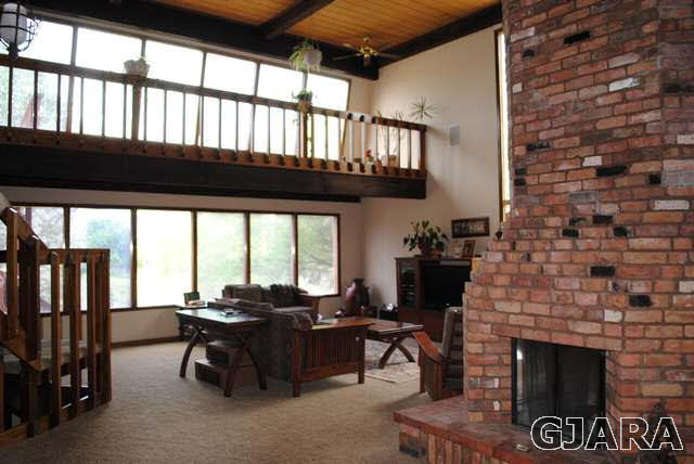 2561 I Road Grand Junction, CO 81505 - Photo 14 of 38 a living room with furniture a fireplace and a floor to ceiling window