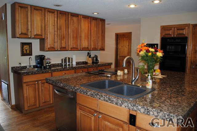 2561 I Road Grand Junction, CO 81505 - Photo 19 of 38 a kitchen with stainless steel appliances granite countertop a sink stove and cabinets