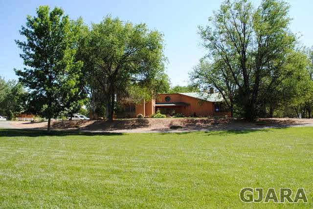 2561 I Road Grand Junction, CO 81505 - Photo 32 of 38 a view of a swimming pool with a bench and trees in the background