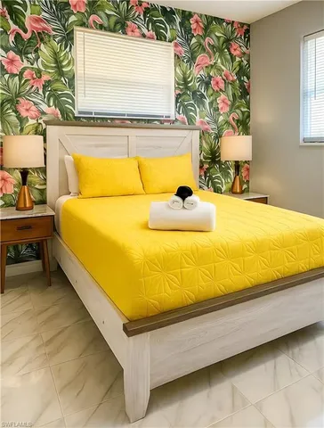 a bed sitting in a bedroom next to a window with potted plants