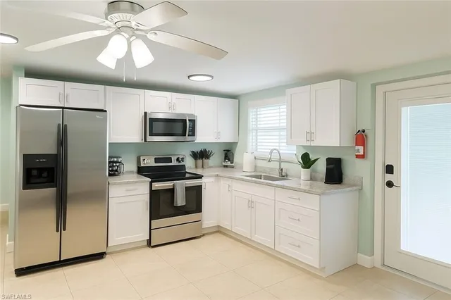 a kitchen with stainless steel appliances granite countertop a refrigerator a stove a sink and a microwave