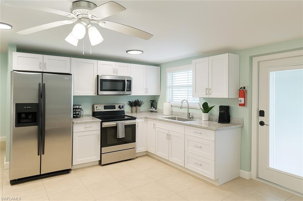 726 Park Avenue Naples, FL 34110 - Photo 11 of 32 a kitchen with stainless steel appliances granite countertop a refrigerator a stove a sink and a microwave