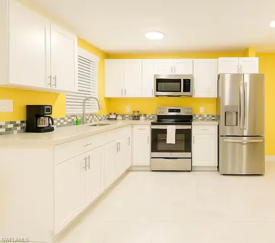 a kitchen with stainless steel appliances granite countertop a stove a sink and a refrigerator