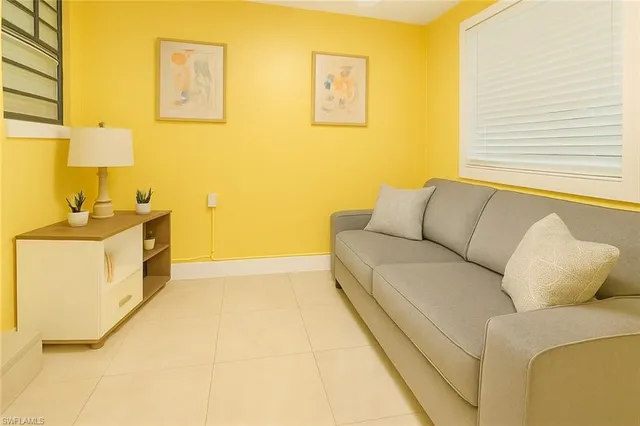 a living room with a couch and a stove next to a window