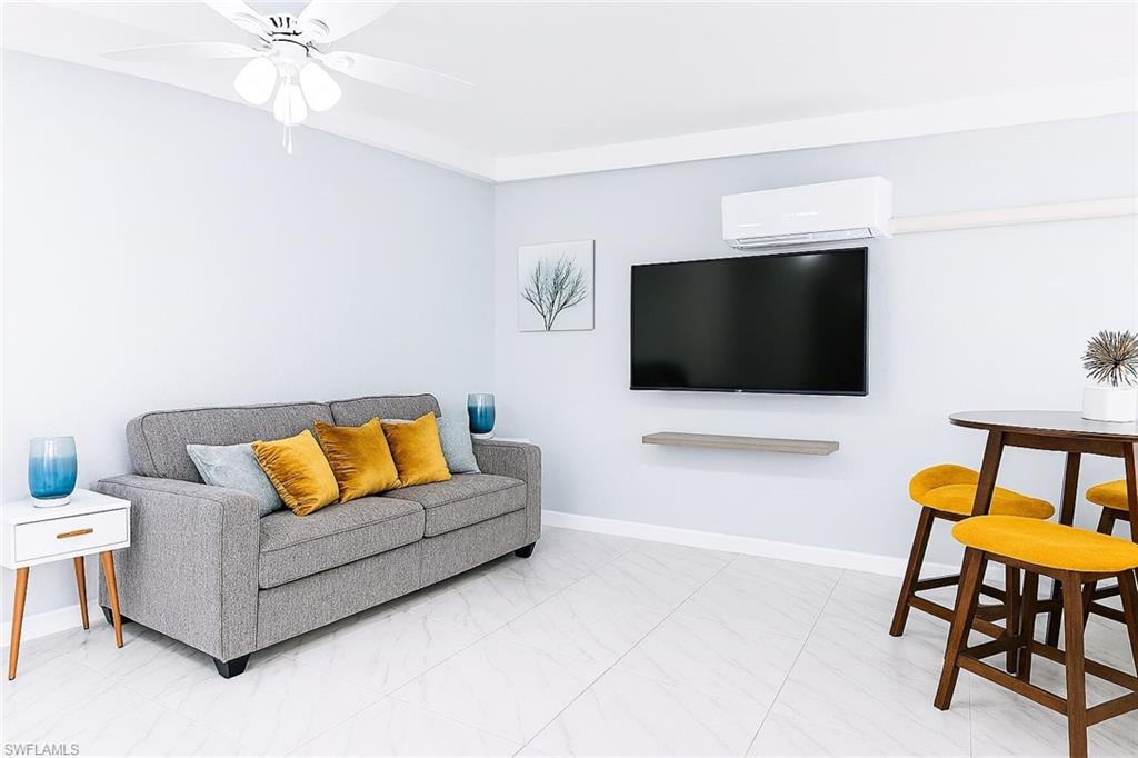 726 Park Avenue Naples, FL 34110 - Photo 3 of 32 a living room with furniture and a flat screen tv