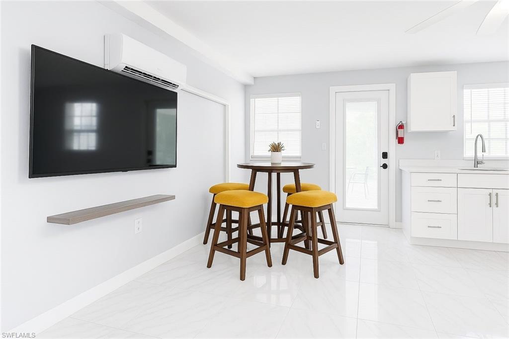726 Park Avenue Naples, FL 34110 - Photo 4 of 32 a living room with furniture and a flat screen tv