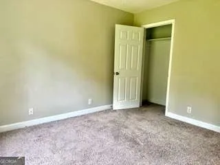an empty room with closet and a window