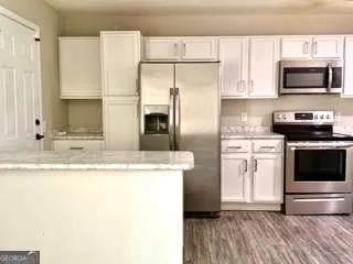 a kitchen with stainless steel appliances granite countertop a stove a sink and a microwave