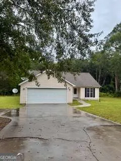 front view of a house next to a yard with a large tree