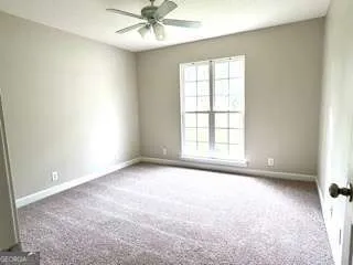 an empty room with a window and a fan