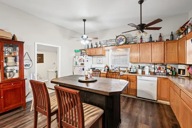 a kitchen with granite countertop a table chairs stove and wooden floor