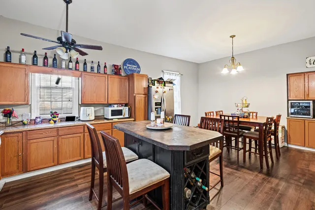 a view of a dining room and livingroom with furniture wooden floor a chandelier