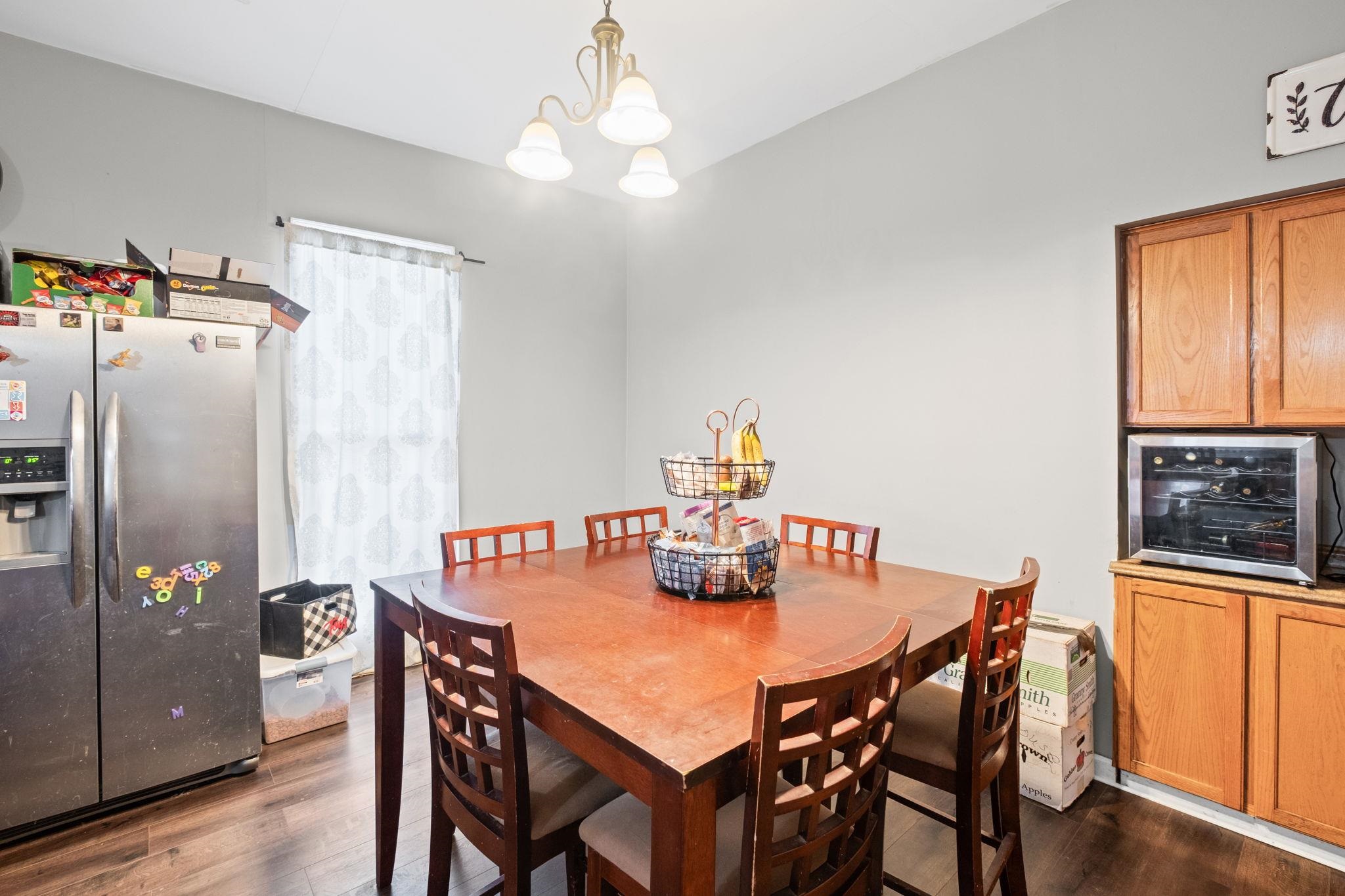 301 North Maple Street Covington, TN 38019 - Photo 19 of 26 a dining room with furniture a chandelier and wooden floor