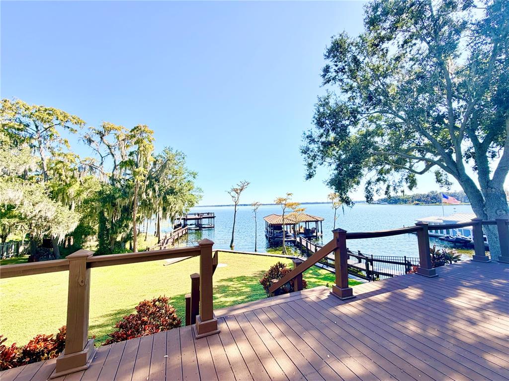 5243 West Lake Butler Road Windermere, FL 34786 - Photo 38 of 43 a view of a deck with table and chairs with wooden floor and fence