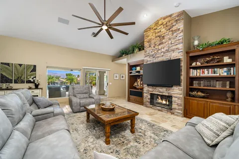 a living room with furniture a flat screen tv and a dining table