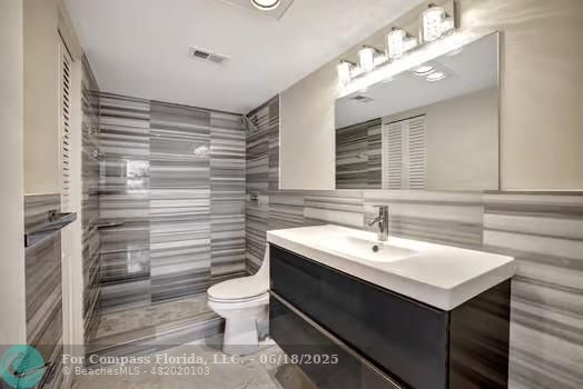 1901 South Ocean Drive, Unit 202 Hollywood, FL 33019 - Photo 9 of 11 a bathroom with a sink toilet and mirror