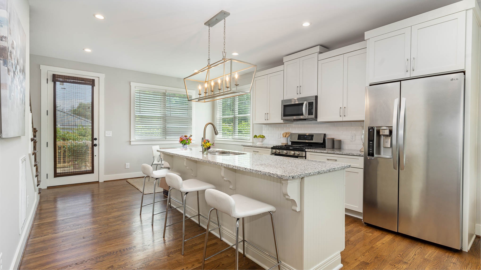 1153 Carter Street Franklin, TN 37064 - Photo 7 of 24 a kitchen with stainless steel appliances granite countertop a refrigerator a stove a sink dishwasher a dining table and chairs with wooden floor