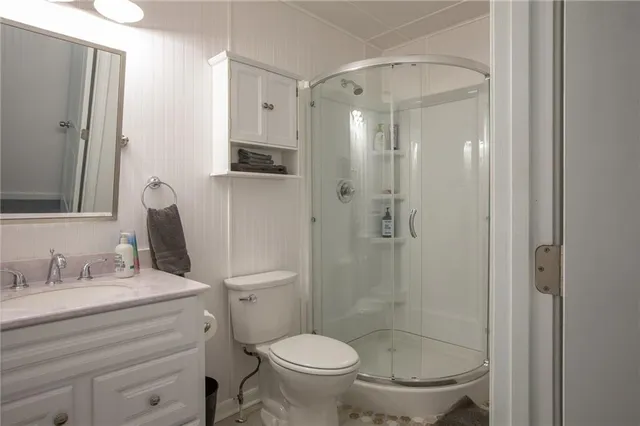 a bathroom with a granite countertop toilet sink shower and mirror