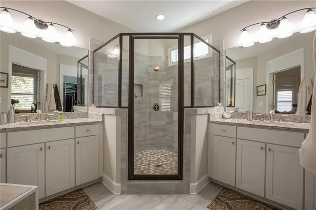 a bathroom with a double vanity sink mirror and shower