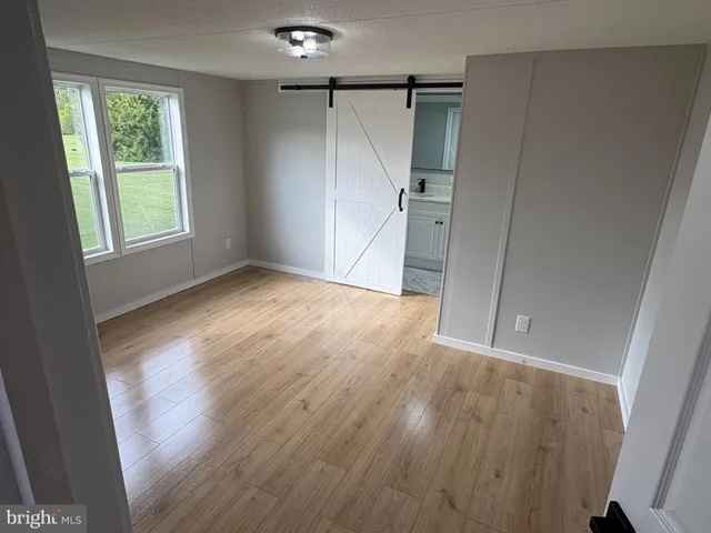 an empty room with wooden floor and a window