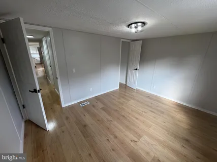 an empty room with wooden floor and entrance