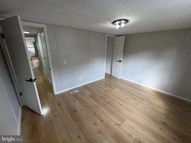 an empty room with wooden floor and entrance