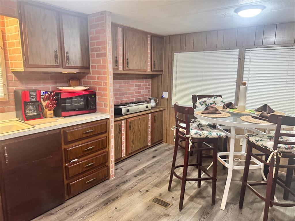 11970 Southwest Loop Terrace Arcadia, FL 34269 - Photo 20 of 37 a kitchen with stainless steel appliances kitchen island granite countertop a table chairs sink and cabinets