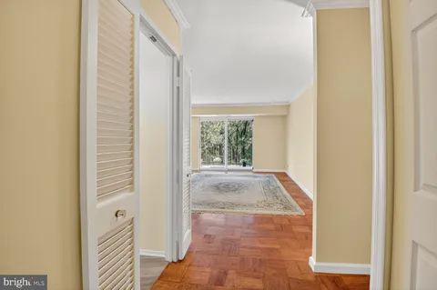 a view of a hallway with wooden floor and a window