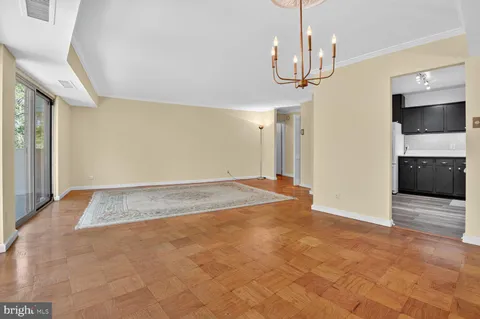 a view of a hallway with wooden floor and chandelier