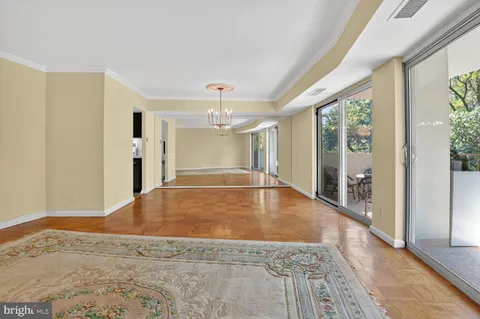a view of a hallway with wooden floor and chandelier