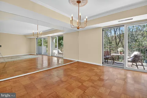 a view of an empty room with furniture and a large window