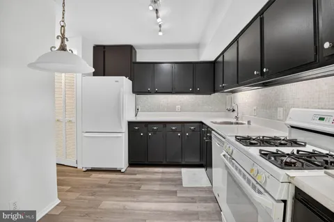 a kitchen with a stove a refrigerator and a sink