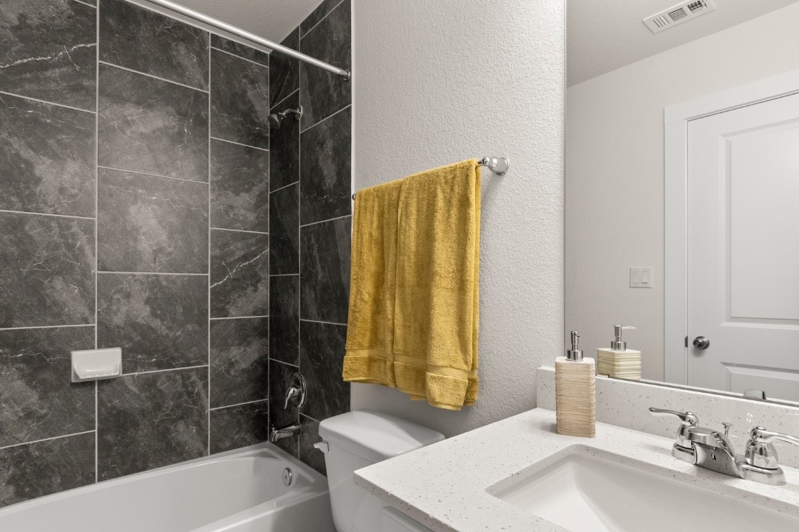 701 White Steppe Way Georgetown, TX 78626 - Photo 26 of 35 Bathroom featuring a textured wall, vanity, and bathing tub / shower combination