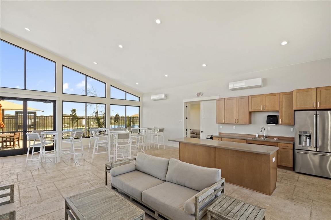 701 White Steppe Way Georgetown, TX 78626 - Photo 31 of 35 Kitchen with high end fridge, a center island, recessed lighting, high vaulted ceiling, and an AC wall unit