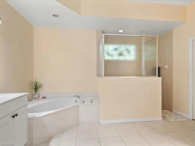 a spacious bathroom with a granite countertop sink mirror and bathtub