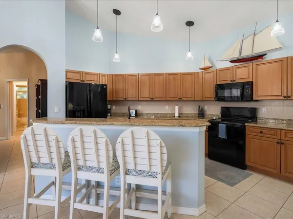 a kitchen with stainless steel appliances granite countertop a stove a sink a microwave a center island and a refrigerator
