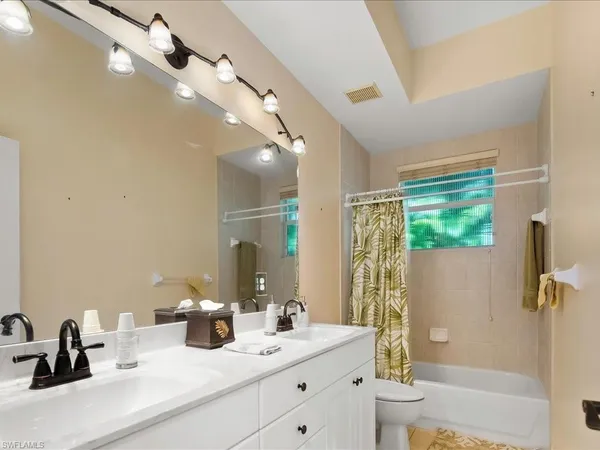 a bathroom with a double vanity sink toilet and shower