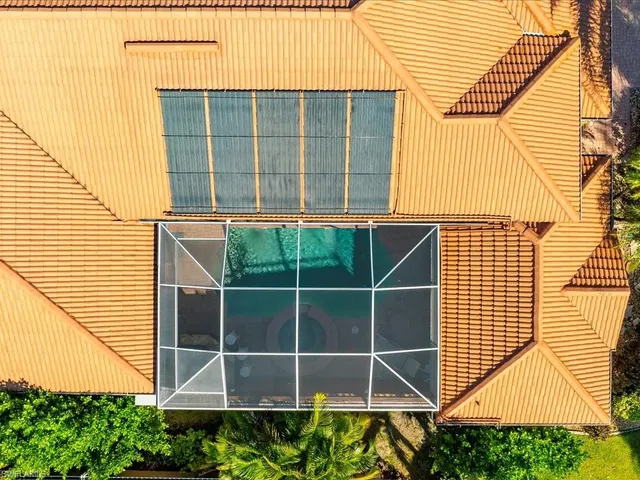 an aerial view of residential houses with outdoor space and trees