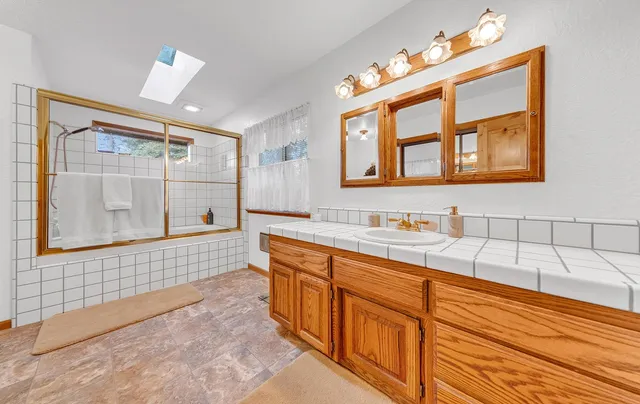 a bathroom with a sink mirror and a bathtub