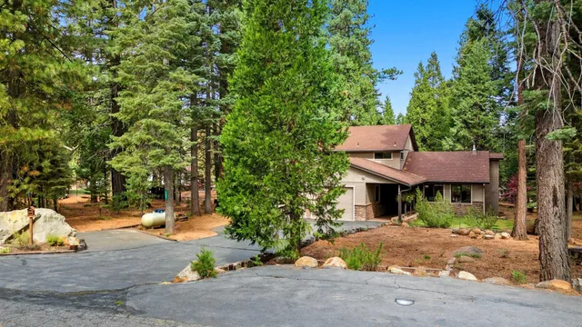a view of house with a yard and potted plants