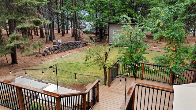 an aerial view of residential house with outdoor space and trees all around