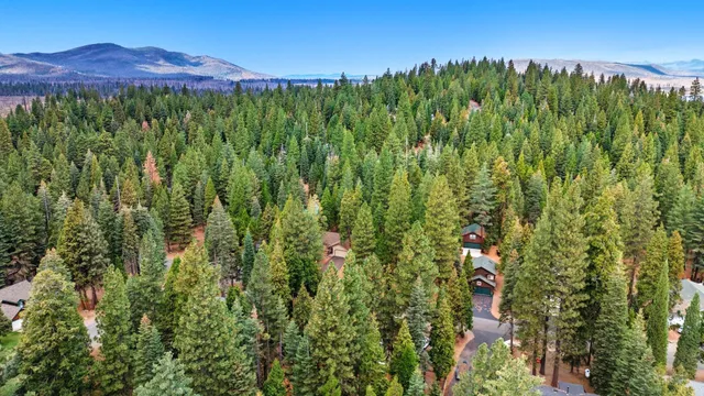 an aerial view of a house with a yard and lake view