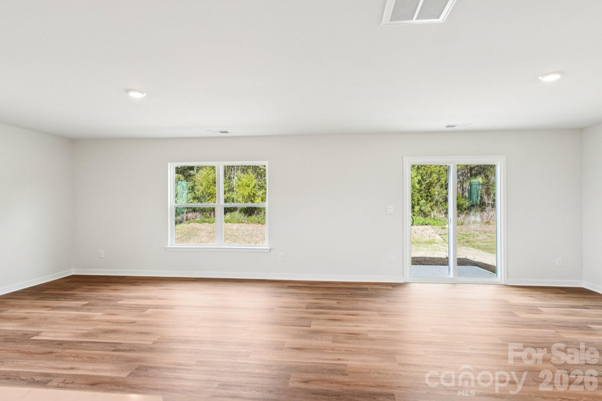 569 North Sparkleberry Street Chester, SC 29706 - Photo 5 of 40 an empty room with wooden floor and windows