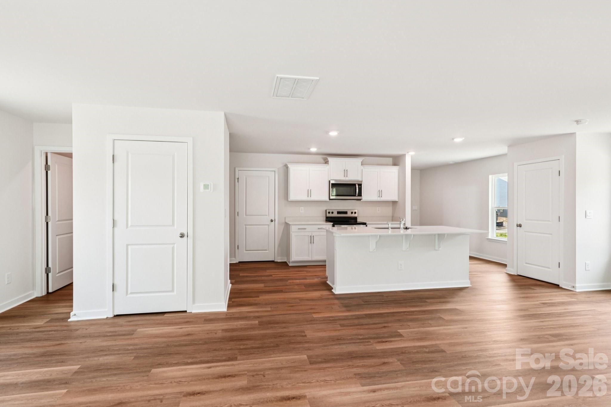 569 North Sparkleberry Street Chester, SC 29706 - Photo 8 of 40 a view of kitchen with kitchen island sink refrigerator and white cabinets with wooden floor
