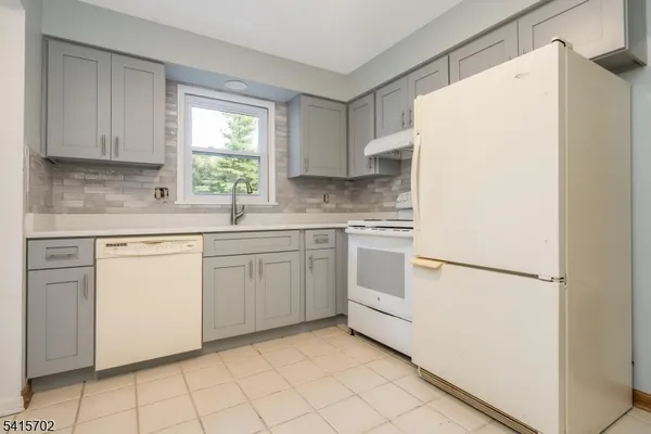a kitchen with white cabinets and white appliances