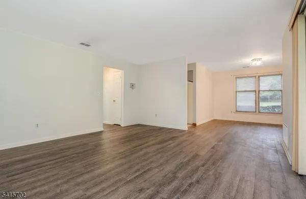 an empty room with wooden floor and window
